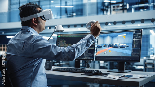Automotive Engineer Using a VR Software to Work on Electric Motor and Vehicle Platform in Interactive Environment in a Factory Office. Industrial Engineer Using Headset and Controllers. photo