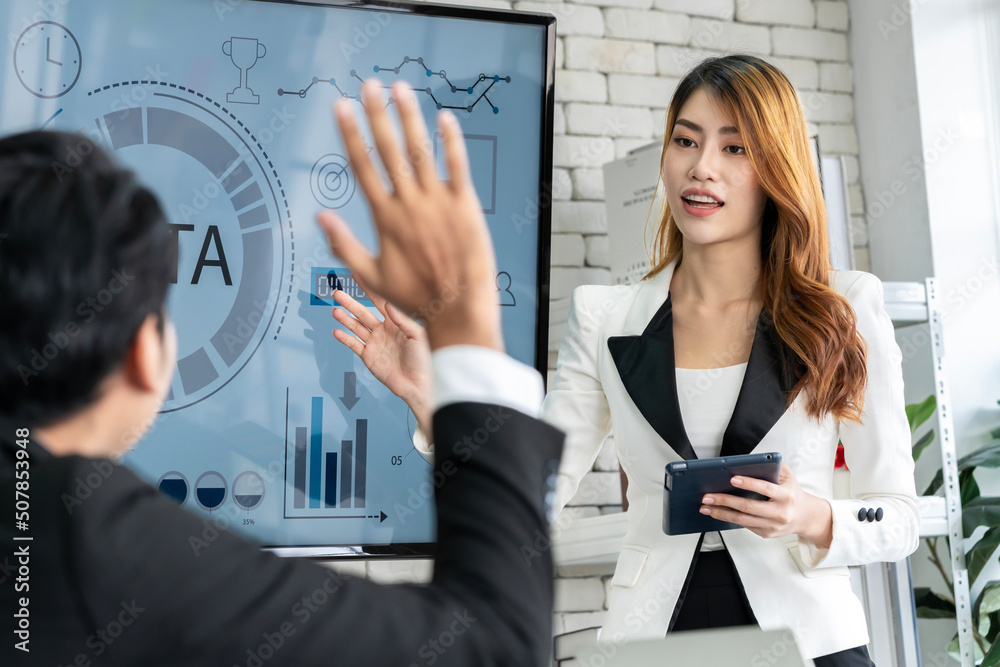 An Asian businessman is presenting his company performance report to his boss or group of male and female colleagues with confidence and professionalism. An Asian businessman is presenting his company performance report to his boss or group of male and female colleagues with confidence and professionalism.
