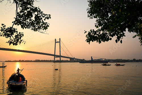 Silhouette sunset on river Hooghly with Vidyasagar setu (bridge) at the backdrop. Photograph taken from Princep Ghat, Kolkata, India.