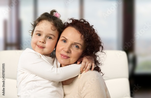 Cheerful preschool kid hugging happy mom with love, gratitude, tenderness.