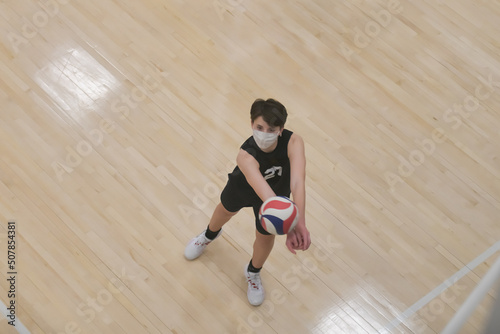 Masked volleyball player passing the ball