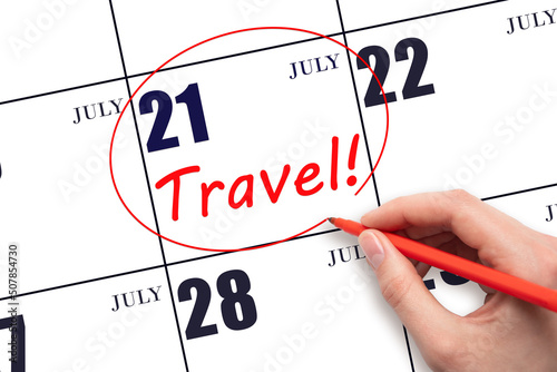 21st day ofJuly. Hand drawing a red circle and writing the text TRAVEL on the calendar date 21July. Travel planning. Summer month. Day of the year concept. photo