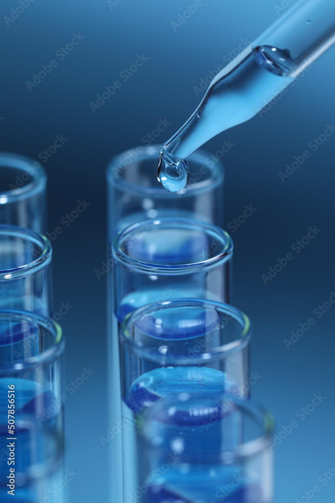 Dripping reagent into test tube on light blue background, closeup. Laboratory analysis Dripping reagent into test tube on light blue background, closeup. Laboratory analysis