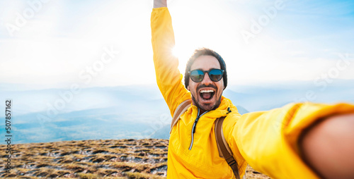 Happy man taking selfie on the top of the mountain - Millenial influencer on social media - Hiker on trekking excursion