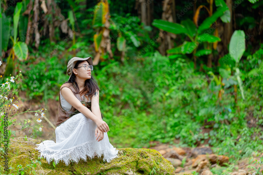 pregnant woman sitting at the waterfall pregnant woman sitting at the waterfall