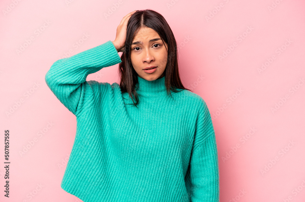 Young hispanic woman isolated on pink background being shocked, she has remembered important meeting.