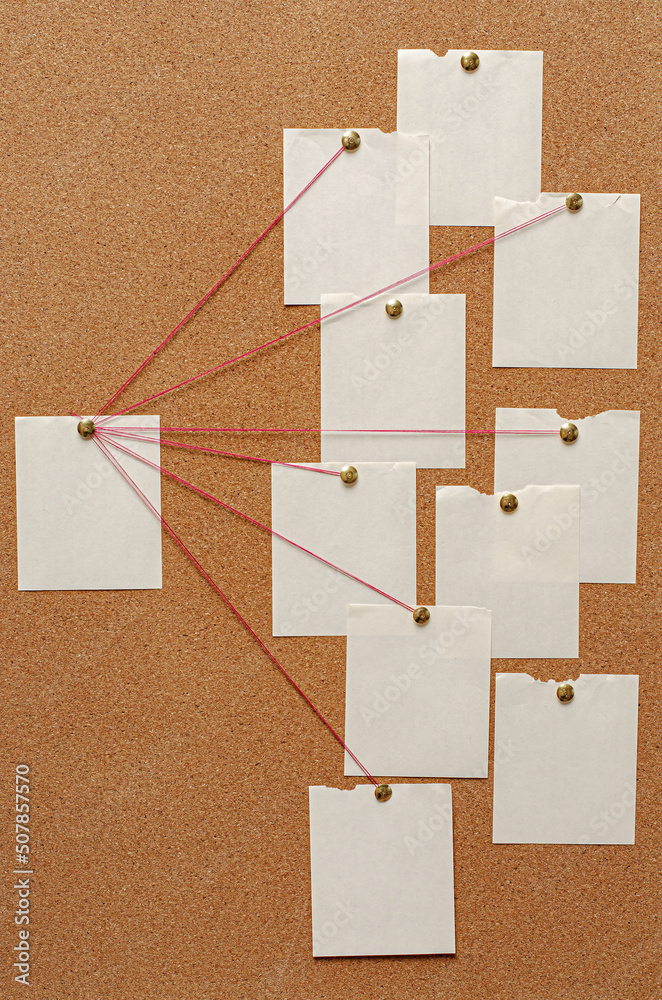 Blank paper notes are pinned to a cork board. The concept of detective ...