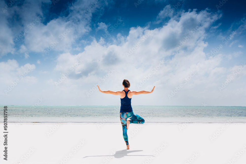 Caucasian woman practicing yoga at seashore Caucasian woman practicing yoga at seashore
