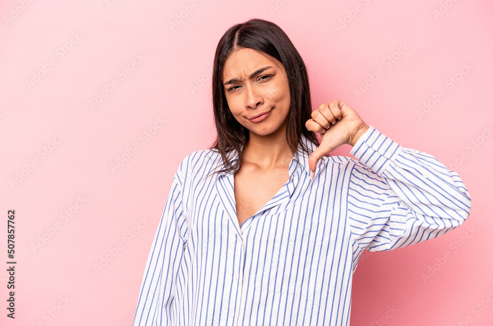 Young hispanic woman isolated on pink background showing thumb down, disappointment concept. Young hispanic woman isolated on pink background showing thumb down, disappointment concept.