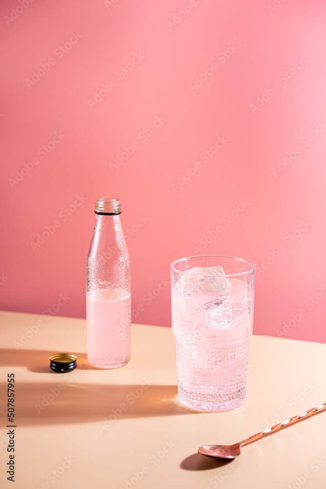 Summer refreshment pink drink with ice. Light pink rose cocktail on a pink background with bright shadows Summer refreshment pink drink with ice. Light pink rose cocktail on a pink background with bright shadows