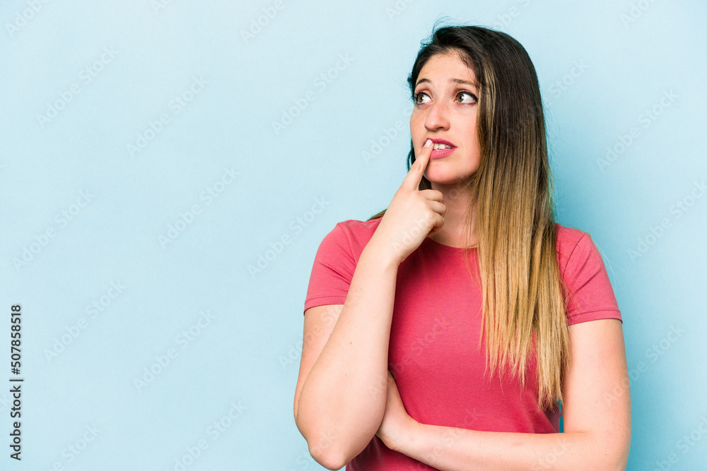 Young caucasian woman isolated on blue background looking sideways with doubtful and skeptical expression. Young caucasian woman isolated on blue background looking sideways with doubtful and skeptical expression.