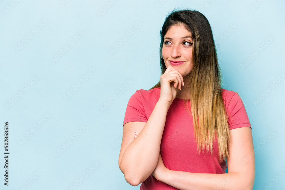 Young caucasian woman isolated on blue background looking sideways with doubtful and skeptical expression. Young caucasian woman isolated on blue background looking sideways with doubtful and skeptical expression.