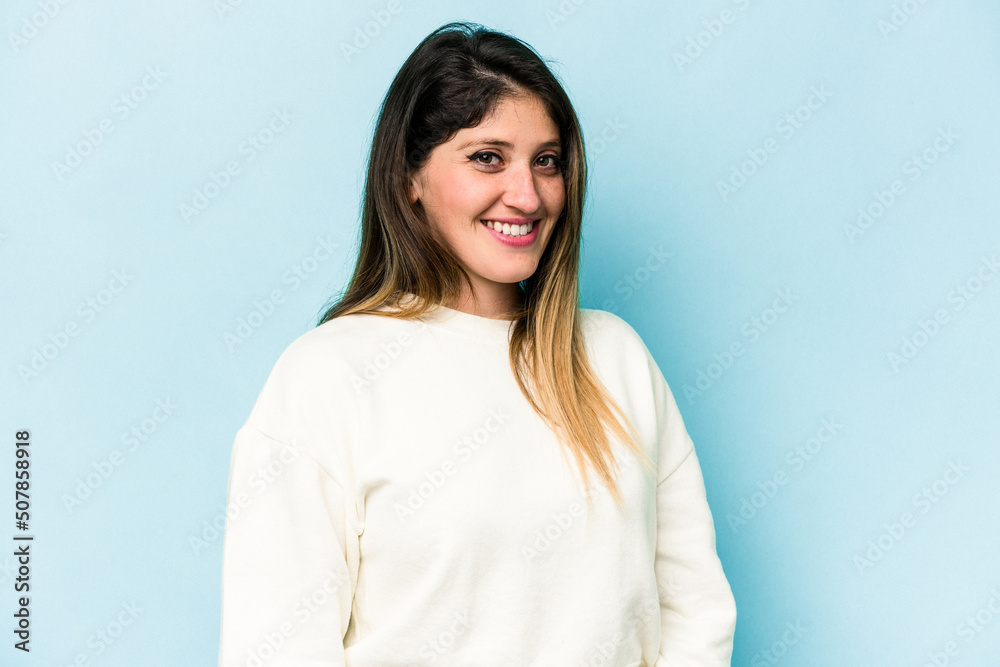 Young caucasian woman isolated on blue background confident keeping hands on hips. Young caucasian woman isolated on blue background confident keeping hands on hips.