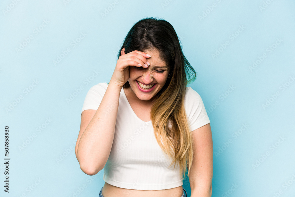 Young caucasian woman isolated on blue background joyful laughing a lot. Happiness concept. Young caucasian woman isolated on blue background joyful laughing a lot. Happiness concept.