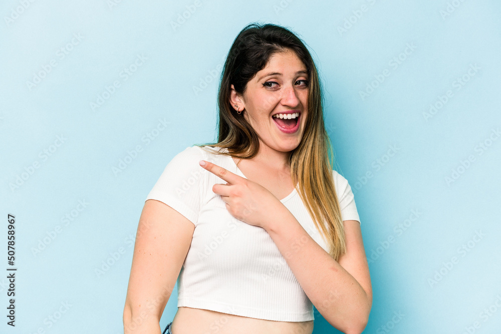 Young caucasian woman isolated on blue background looks aside smiling, cheerful and pleasant. Young caucasian woman isolated on blue background looks aside smiling, cheerful and pleasant.