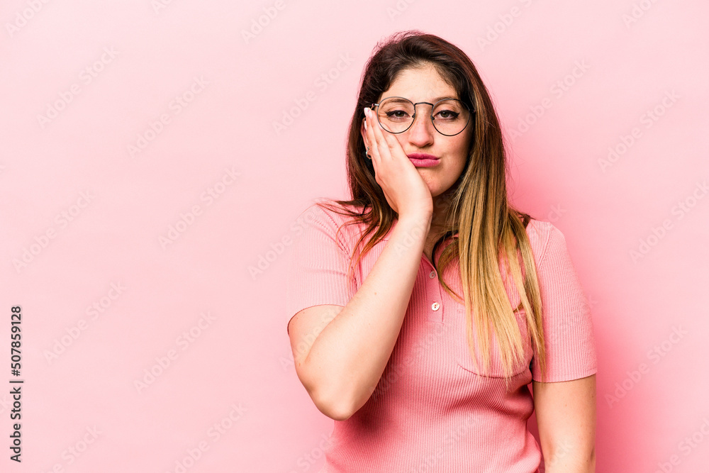 Young caucasian woman isolated on pink background who feels sad and pensive, looking at copy space. Young caucasian woman isolated on pink background who feels sad and pensive, looking at copy space.
