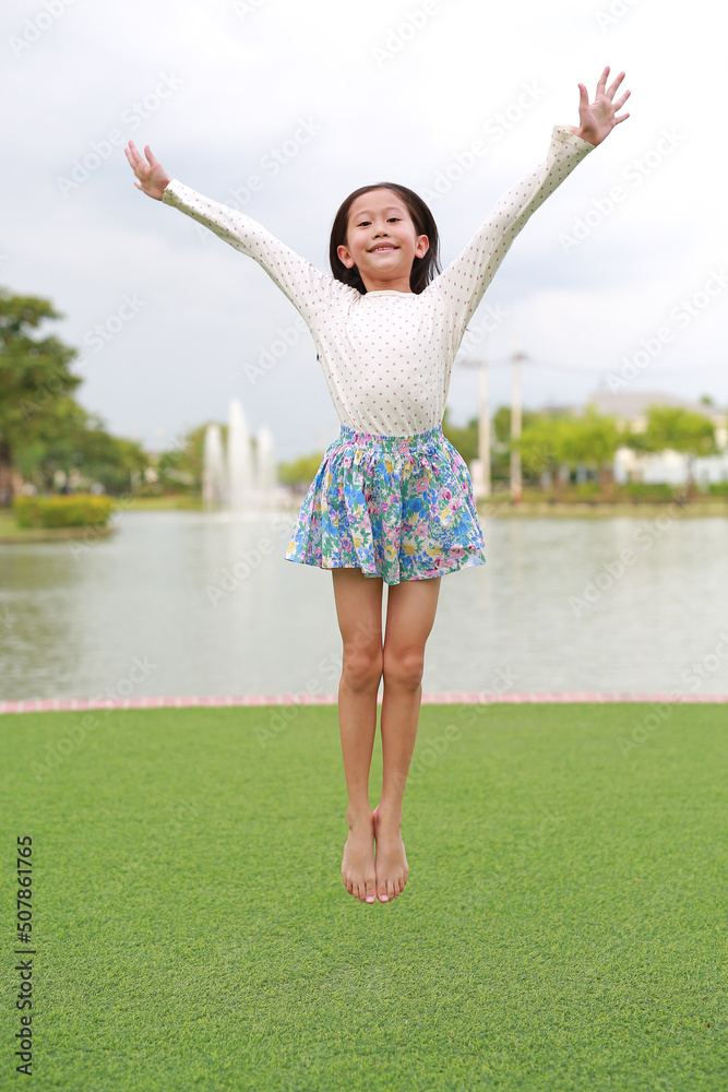 Naklejka premium Happy Asian girl child jumping in the garden outdoor.