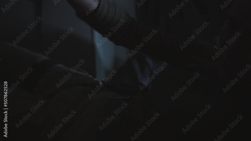 Medium long low angle of woman with shaved head lying on floor in dark public bathroom with lights twitching, defending against living dead, pushing zombie away with shotgun