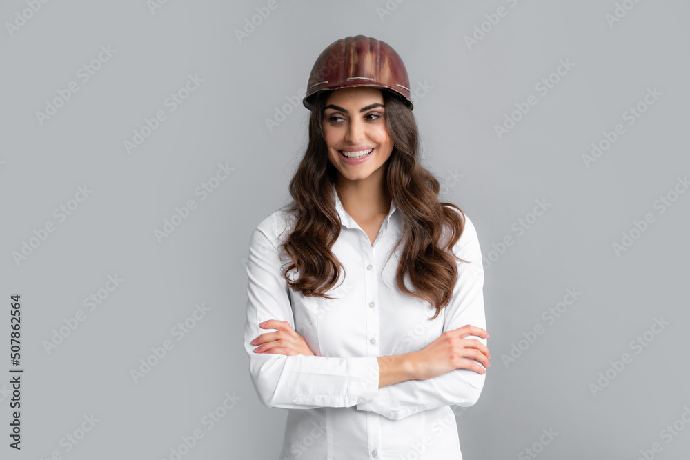 Positive woman in protective helmet isolated on grey background. Architect woman wear helmet and shirt. Positive woman in protective helmet isolated on grey background. Architect woman wear helmet and shirt.