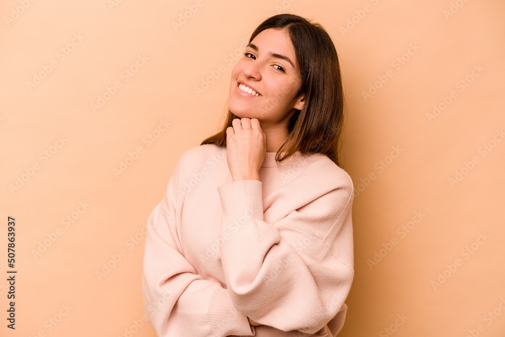 Young hispanic woman isolated on beige background smiling happy and confident, touching chin with hand. Young hispanic woman isolated on beige background smiling happy and confident, touching chin with hand.
