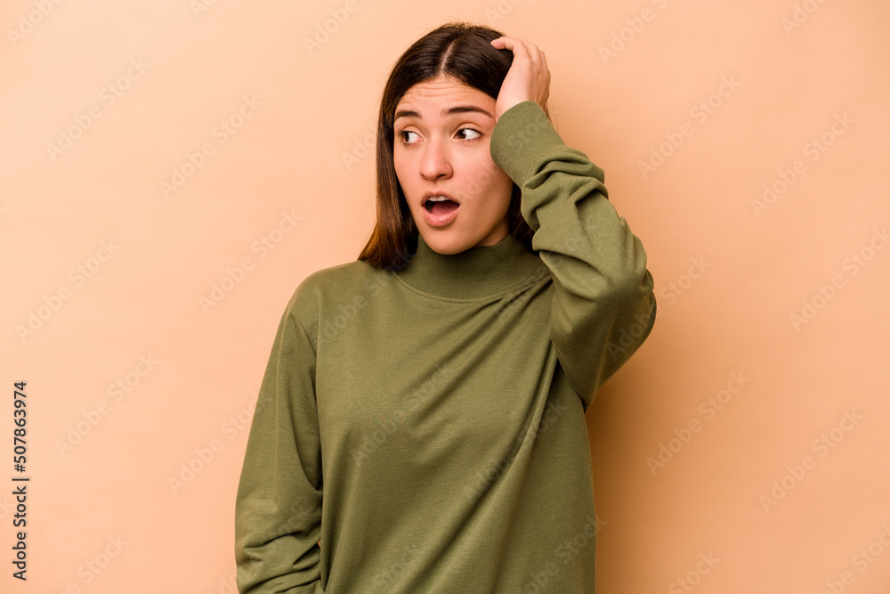Young hispanic woman isolated on beige background being shocked, she has remembered important meeting. Young hispanic woman isolated on beige background being shocked, she has remembered important meeting.
