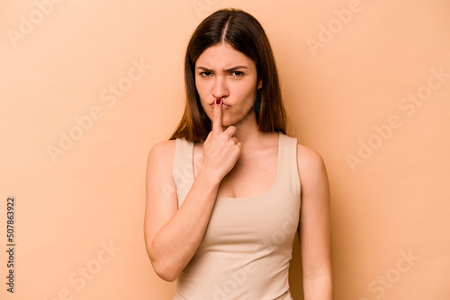 Young hispanic woman isolated on beige background thinking and looking up, being reflective, contemplating, having a fantasy.