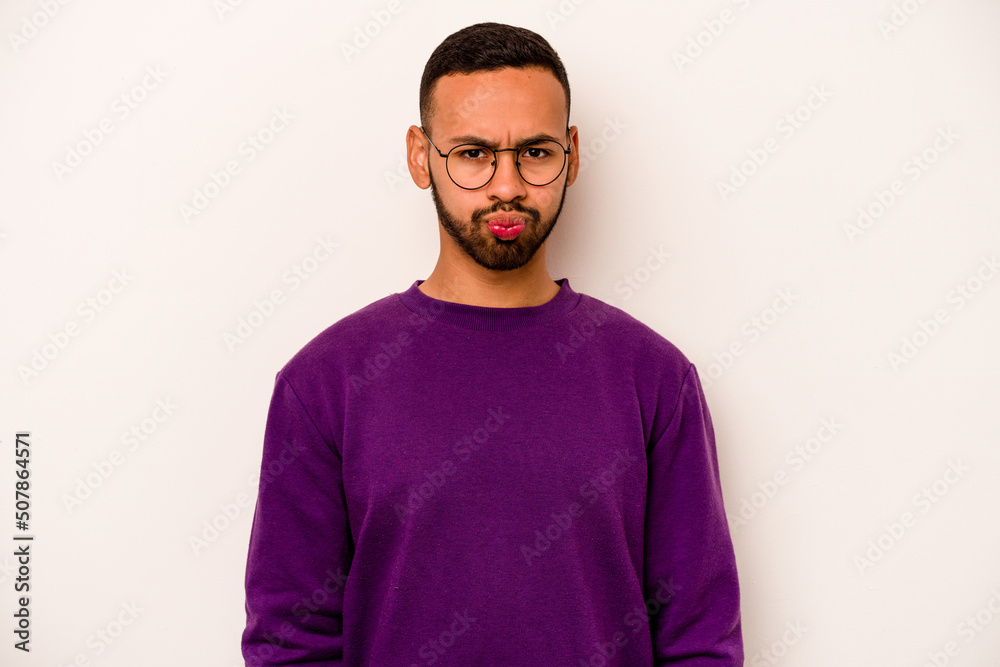 Fototapeta premium Young hispanic man isolated on white background blows cheeks, has tired expression. Facial expression concept.