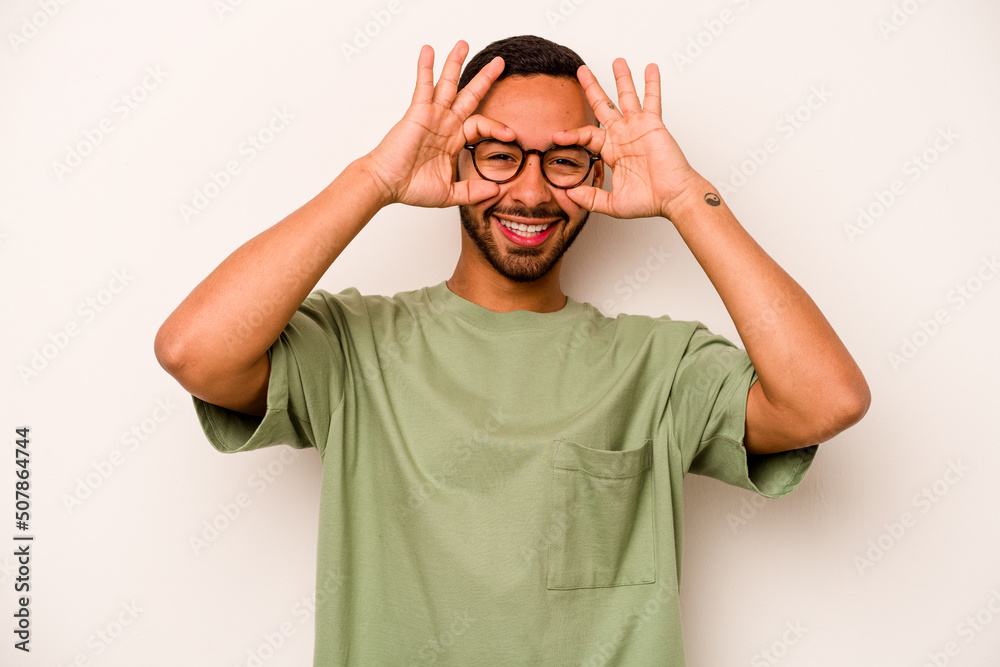 Naklejka premium Young hispanic man isolated on white background excited keeping ok gesture on eye.