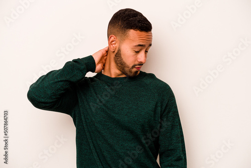 Young hispanic man isolated on white background having a neck pain due to stress, massaging and touching it with hand.