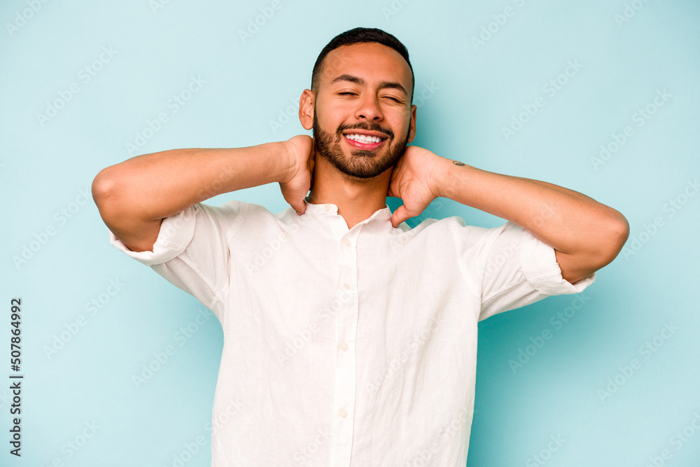 Fototapeta premium Young hispanic man isolated on blue background suffering neck pain due to sedentary lifestyle.