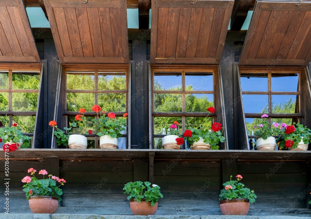 wooden facade of a house with windows and flowers on them