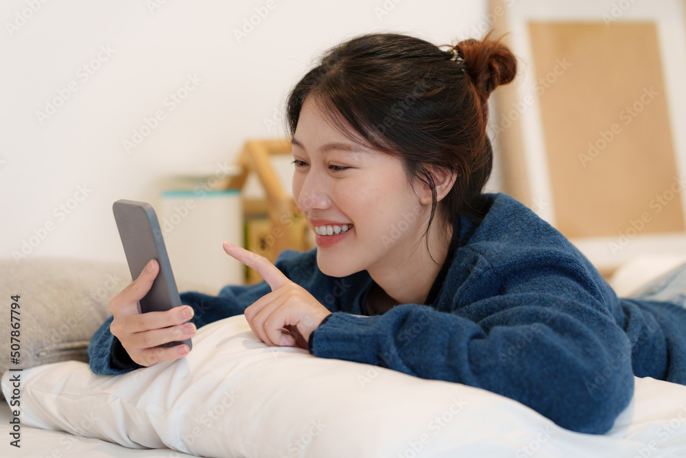 Portrait of Young Asian woman chatting with her friend by smartphone sitting on floor at bedroom. Lifestyle concept. Portrait of Young Asian woman chatting with her friend by smartphone sitting on floor at bedroom. Lifestyle concept.