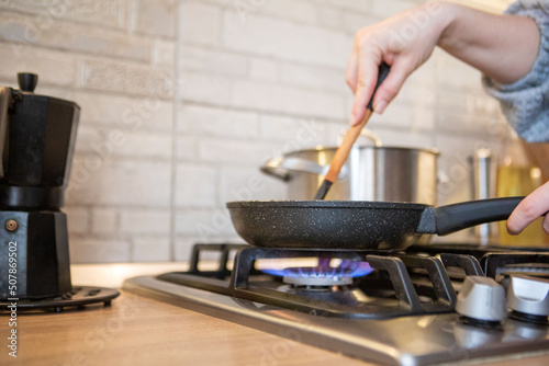 Fotografie frying pan on cooking top blue flame