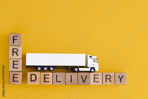 Toy truck with wooden box on yellow background. Delivery concept