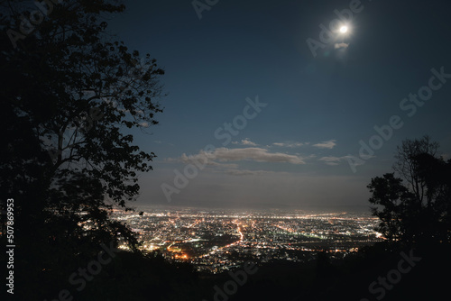 Top view of City night and moon light from the view point on top of mountain. Chiang Mai, Thailand. Aerial view, night city view with night sky.