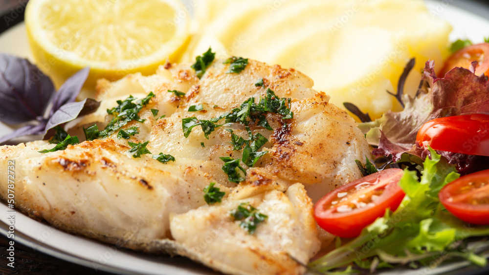 Fried cod loin fillet with mashed potato and vegetable salad served with fresh lemon Fried cod loin fillet with mashed potato and vegetable salad served with fresh lemon