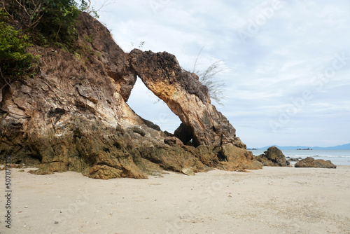 Pierced stone (Khao Hin Thalu) or hole in a massive rocky cliff located on Khao Khwai bay, Koh Phayam island, Ranong province, Thailand. Holes in rocks eroded by ocean waves. 