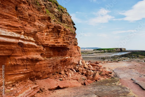 Red cliffside on beach island.