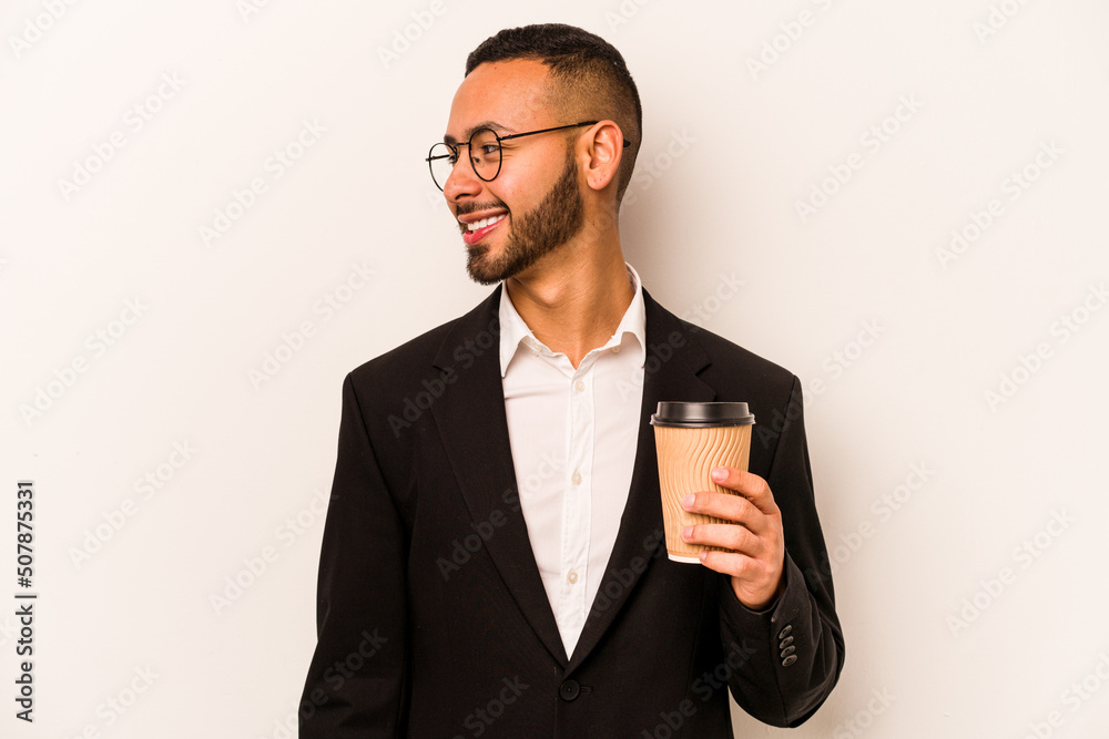 Young business hispanic man holding takeaway coffee isolated on white background looks aside smiling, cheerful and pleasant. Young business hispanic man holding takeaway coffee isolated on white background looks aside smiling, cheerful and pleasant.