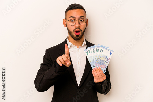 Young business hispanic man holding banknotes isolated on white background having some great idea, concept of creativity.