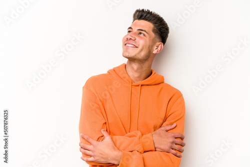 Young caucasian man isolated on white background dreaming of achieving goals and purposes