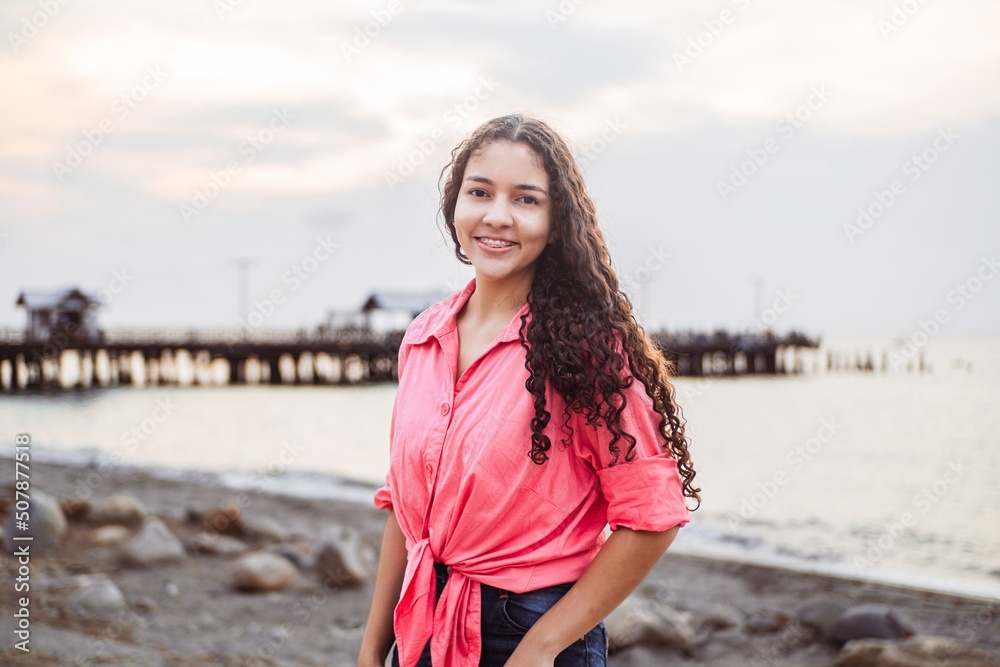 Portrait of a smiling and happy Latin American woman wearing a pink blouse Portrait of a smiling and happy Latin American woman wearing a pink blouse