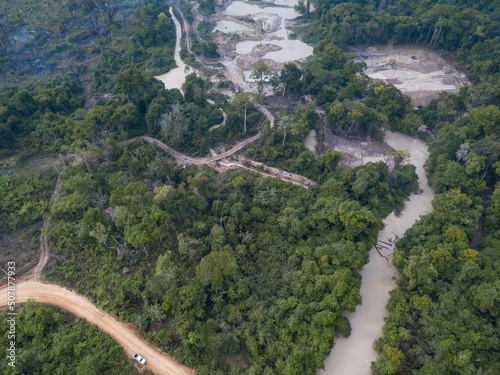 Drone aerial view of illegal gold mining in a destroyed river with water contaminated with mercury and forest trees in an environmental conservation area in the Amazon Rainforest, Brazil. Nature.
