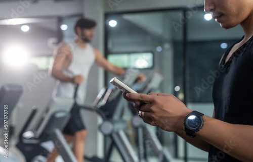 Hands of man use smartphone in fitness during work out