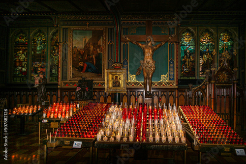 Slika na platnu Colourful votive glass candles with statue of Jesus Christ inside St Joseph orat