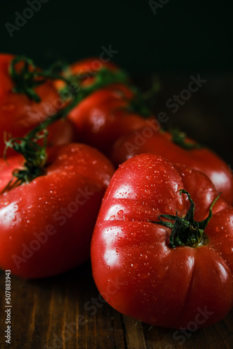 Tomatoes on a branch. Fresh tomatoes on a wooden table. Azeybarjan tomatoes. Ripe tomatoes.