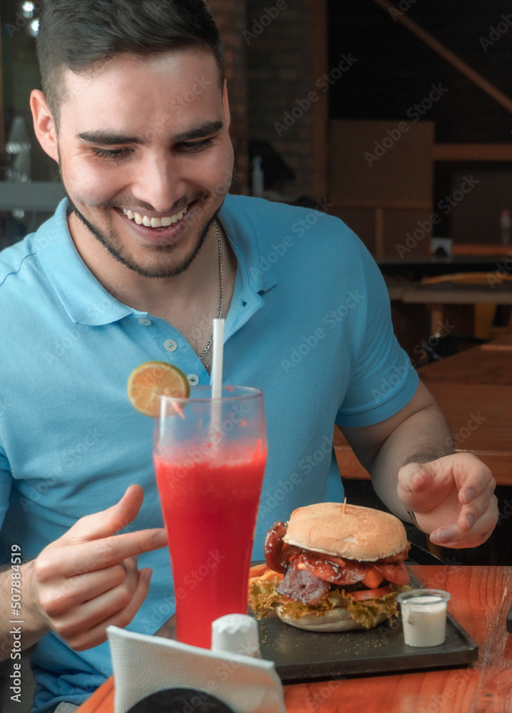 man jives enjoying a meal and a drink, fast food in american type restaurant man jives enjoying a meal and a drink, fast food in american type restaurant