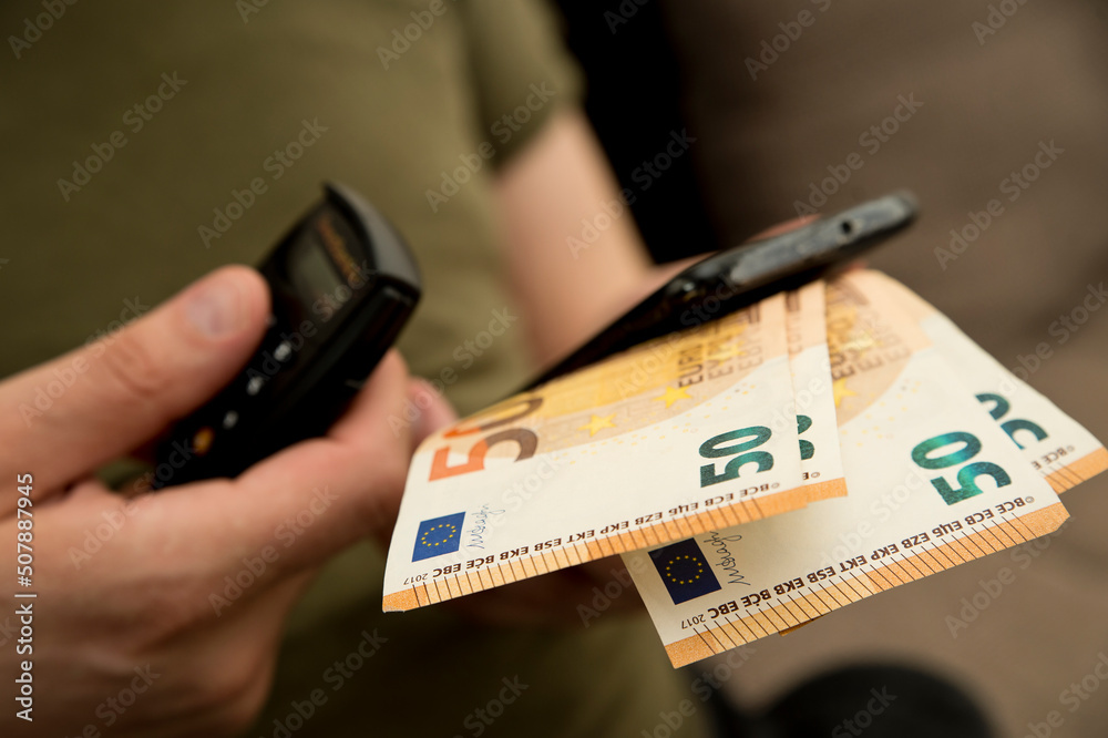 Small electronic password generator used for banking security on on euro banknotes. Saving money concept. Finance, business, investment. Spending cash for unexpected expense. Small electronic password generator used for banking security on on euro banknotes. Saving money concept. Finance, business, investment. Spending cash for unexpected expense.
