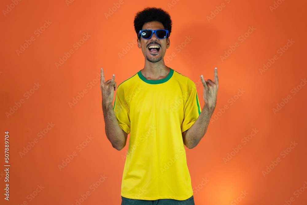 Soccer Brazilian Fan Celebrating Isolated on Orange Background Soccer Brazilian Fan Celebrating Isolated on Orange Background