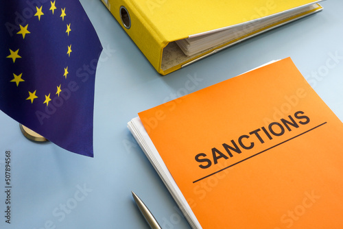 EU flag and sanctions list with a folder.